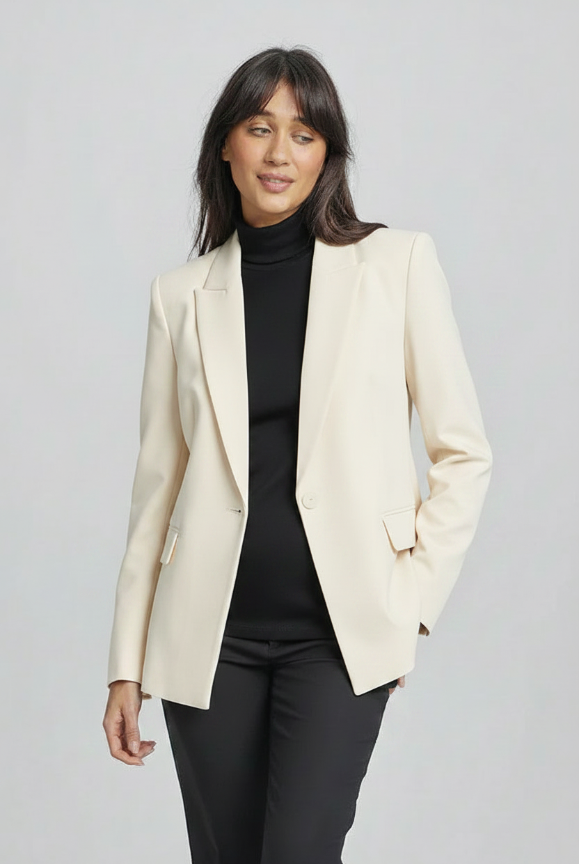 Woman wearing a black turtleneck sweater and pants on a gray background