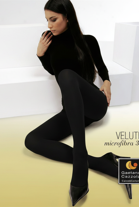 A model wearing black velvet microfibra 3D tights and a black turtleneck top, posing on white geometric steps against a beige floor. Text on the right reads 'CLASSIC', 'VELVETÈ microfibra 3D', '80 DEN', and 'Clementino Cacciatore'.