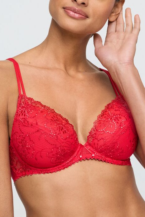 Red lace bra worn by a model on a plain background