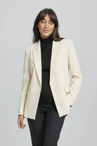 Woman wearing a black turtleneck sweater and pants on a gray background