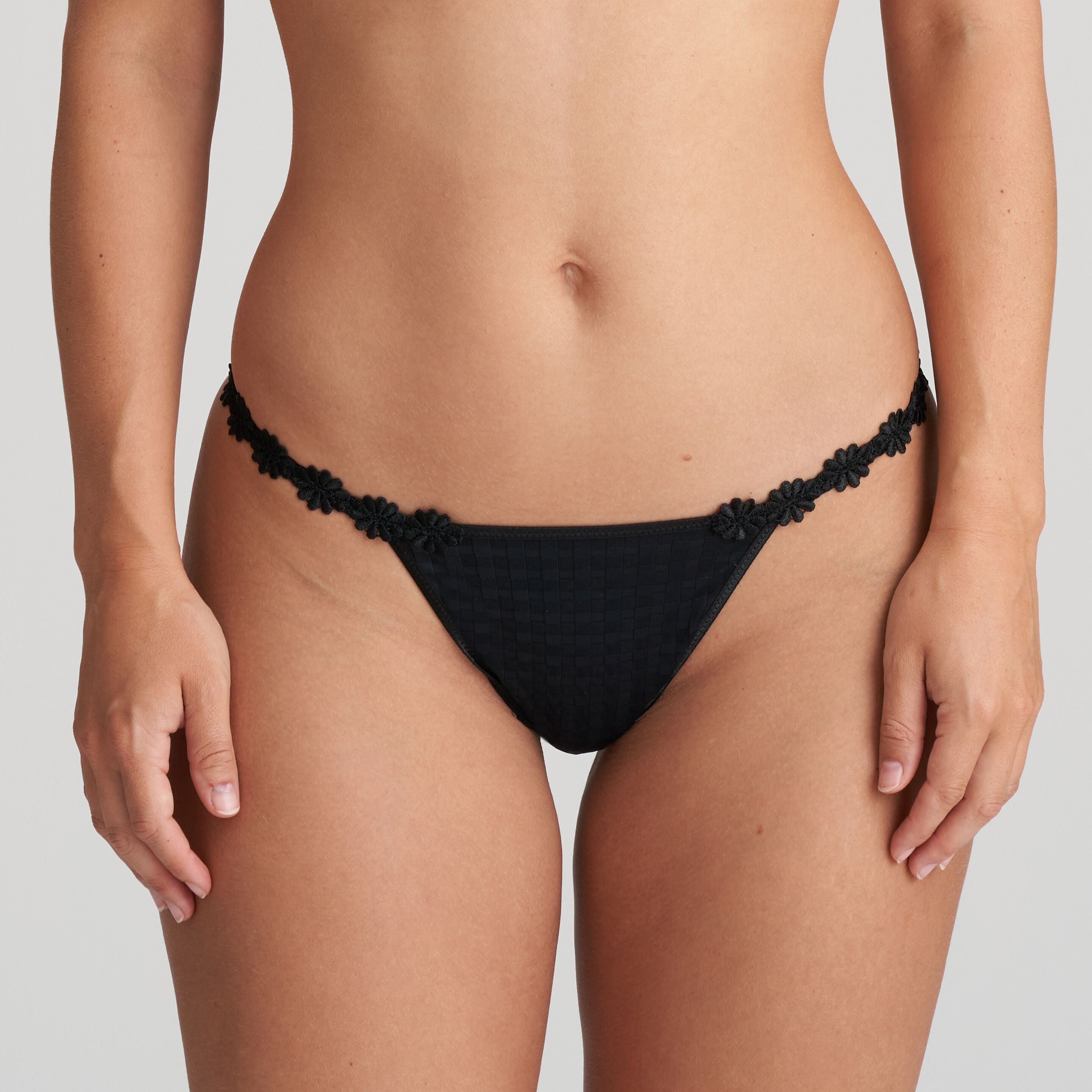 Black thong that is non transparent in front and features delicate floral embroidery soft waistband.