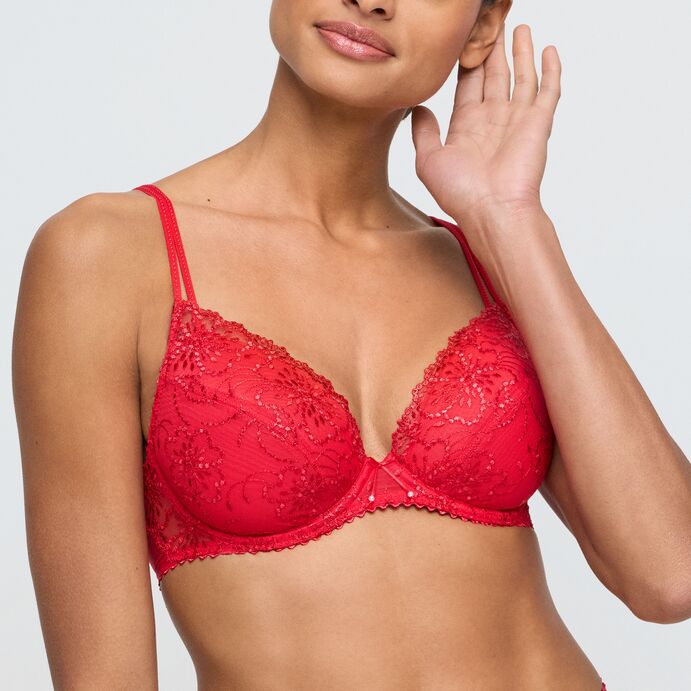 Red lace bra worn by a model on a plain background