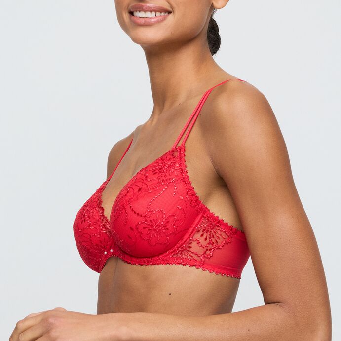 Red lace bra worn by a model on a plain background