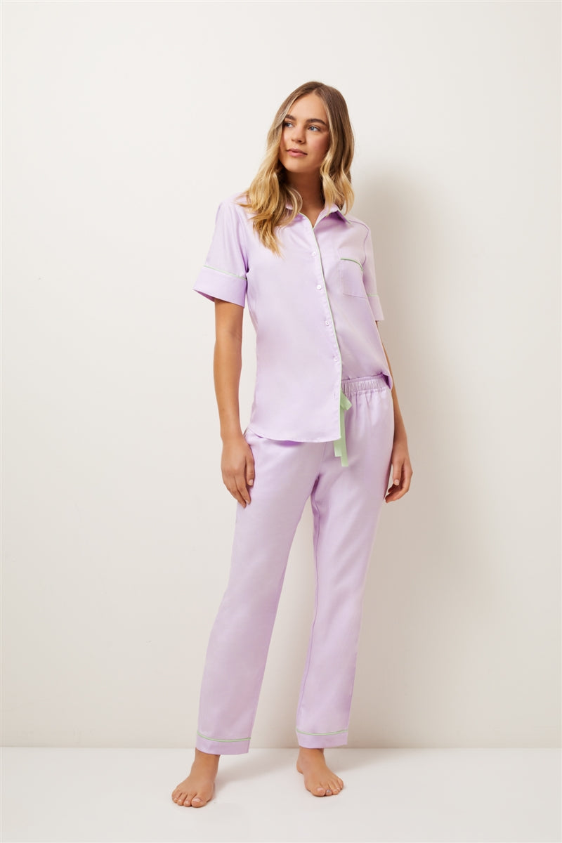 The Jacaranda Pyjama Set in lilac has been created with the perfect short sleeve, featuring a lilac gingham print, mint piping and lilac mother of pearl buttons.